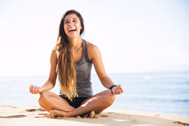 Woman meditating on the beach.