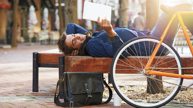 Person reading tablet outside.