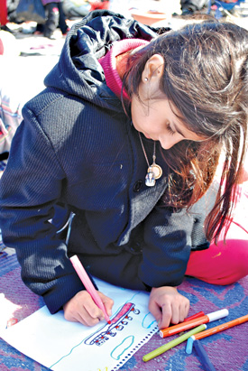 Syrian refugee girl coloring in Lesbos, Greece.