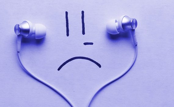 Purple sad face listening to earbuds.