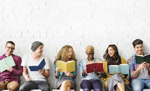 People against a wall reading and talking