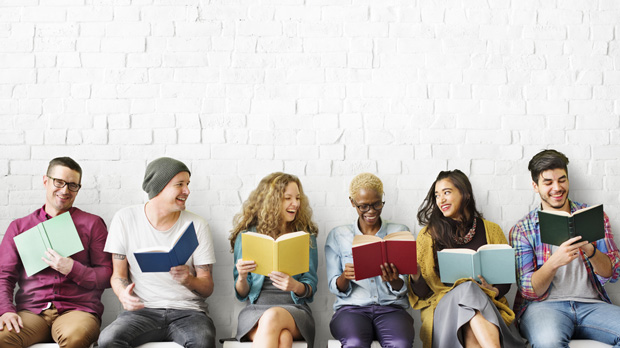 People against a wall reading and talking