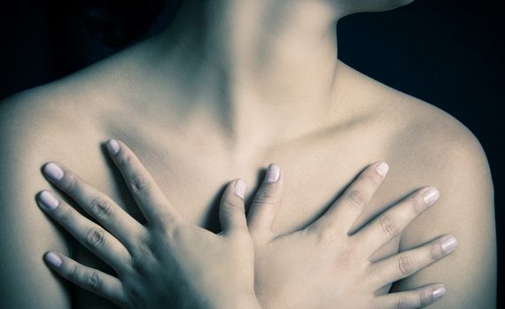 Image of woman embracing her chest.