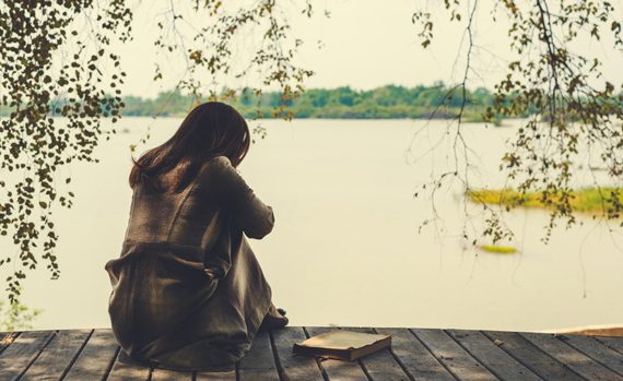 Depressed woman by a lake.