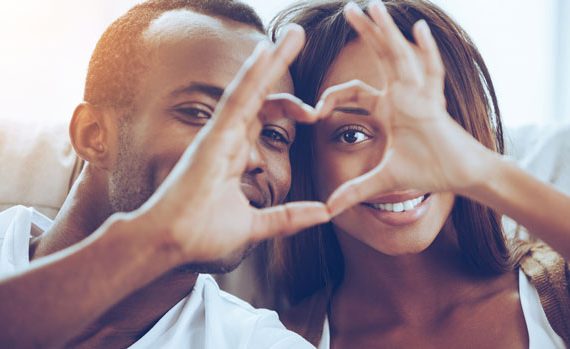 cute couple making a heart with their hands.