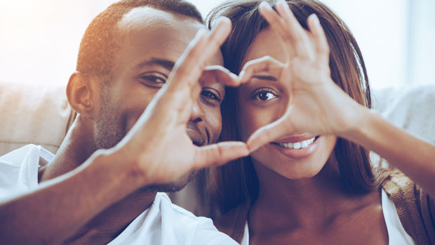 cute couple making a heart with their hands.