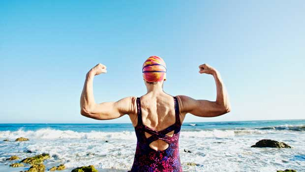 Older lady flexing her muscles before a swim