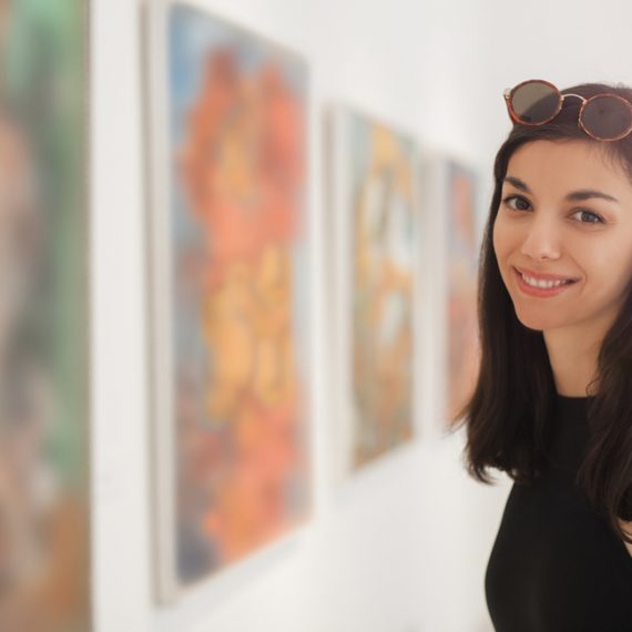 Young woman looking at modern painting in art gallery