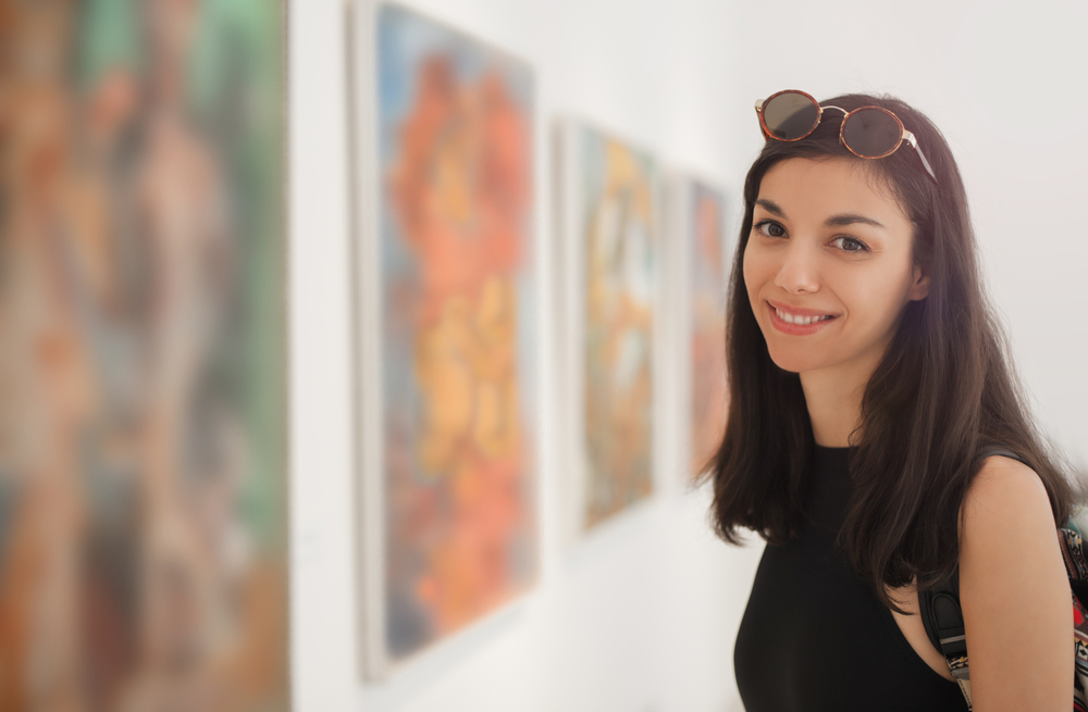 Young woman looking at modern painting in art gallery