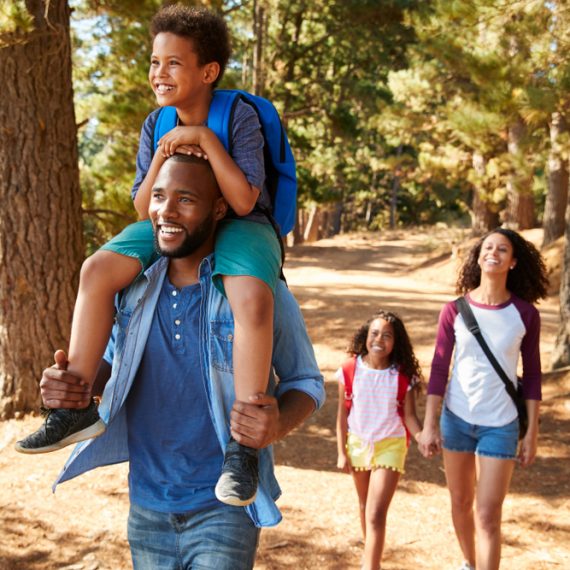 Family On Hiking Adventure Through Forest