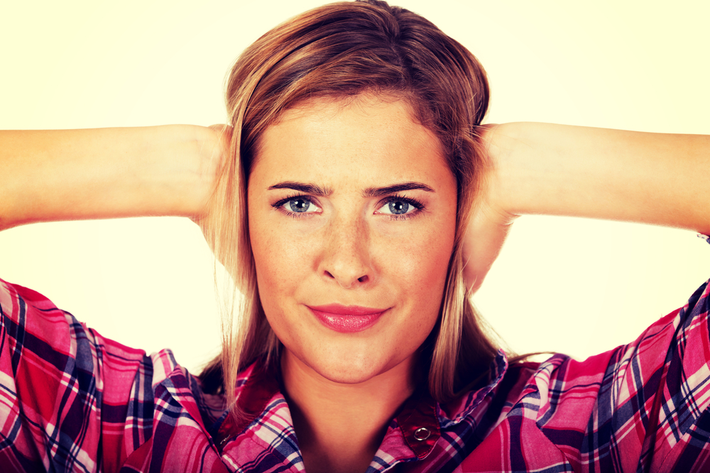 Young woman covering her ears.