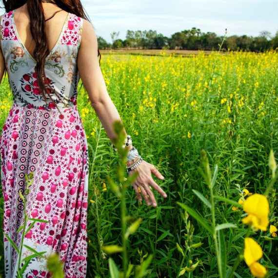 Beautiful carefree woman in fields being happy open hands outdoors on sunset in nature summer.