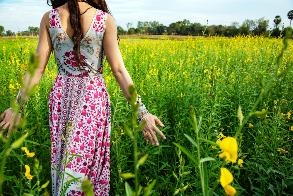 Beautiful carefree woman in fields being happy open hands outdoors on sunset in nature summer.