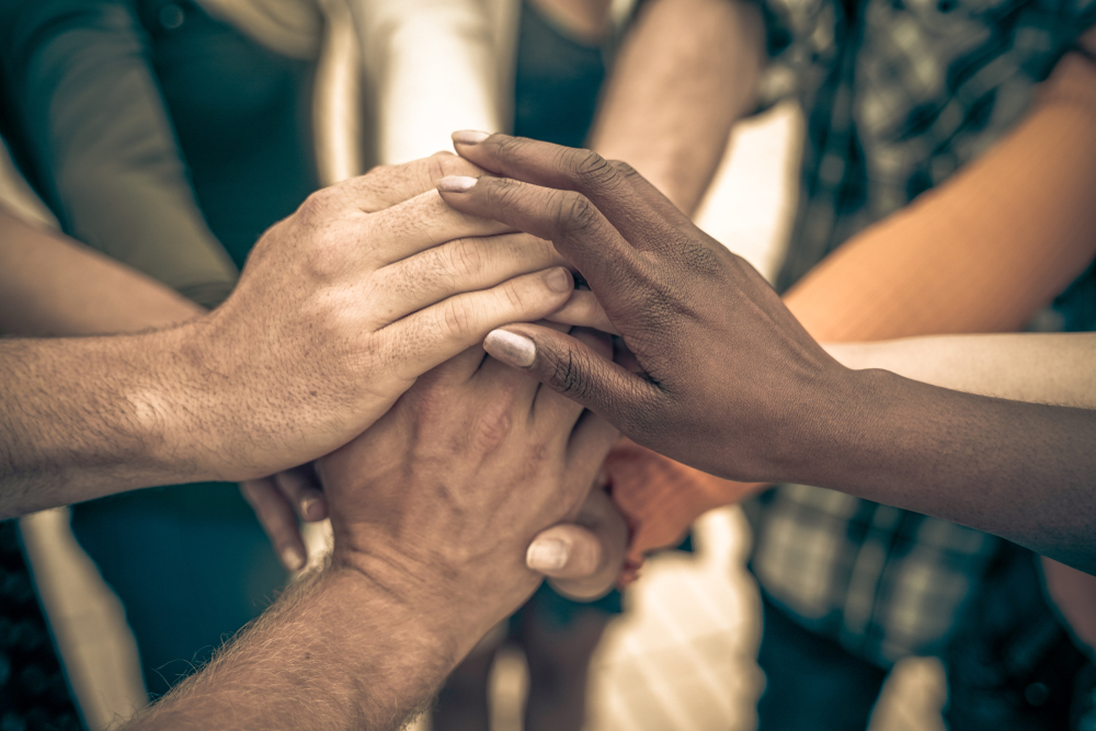 Young people putting their hands together. Friends with stack of hands showing unity and teamwork