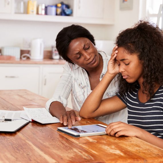 Mother Helps Stressed Teenage Daughter With Homework