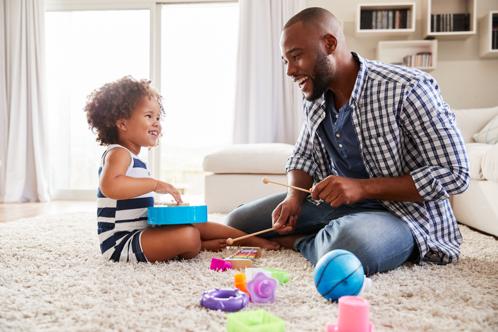 Young father playing with daughter in the sitting room