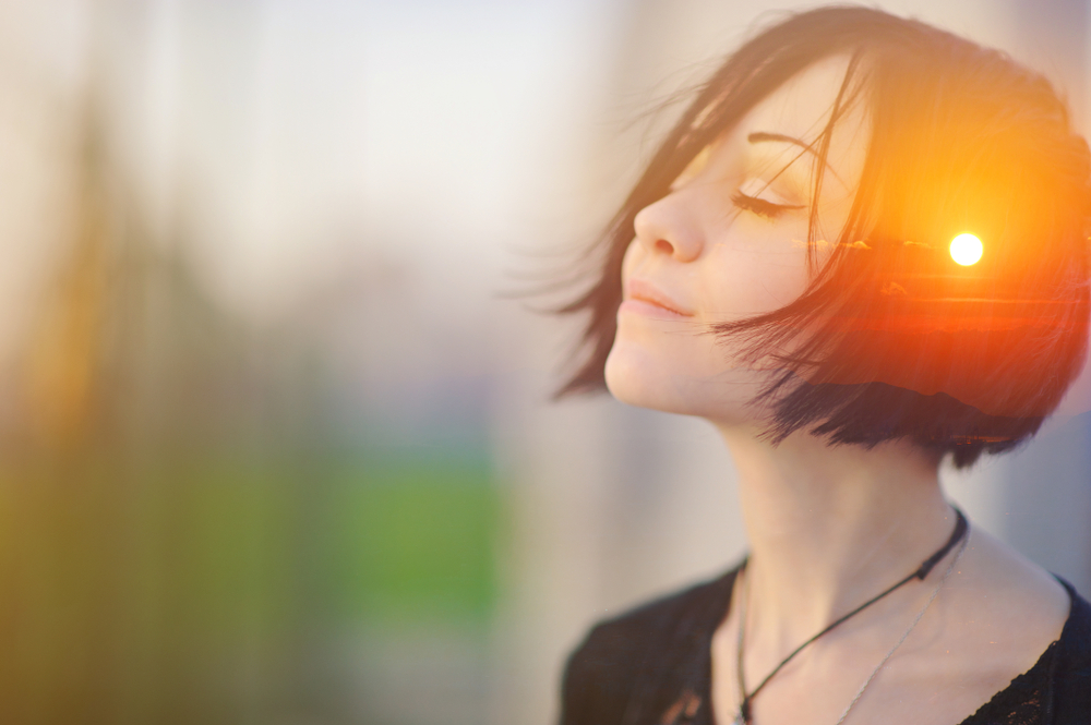 Double multiply exposure portrait of a dreamy cute woman meditating outdoors with eyes closed, combined with photograph of nature, sunrise or sunset, closeup. Psychology freedom power of mind concept