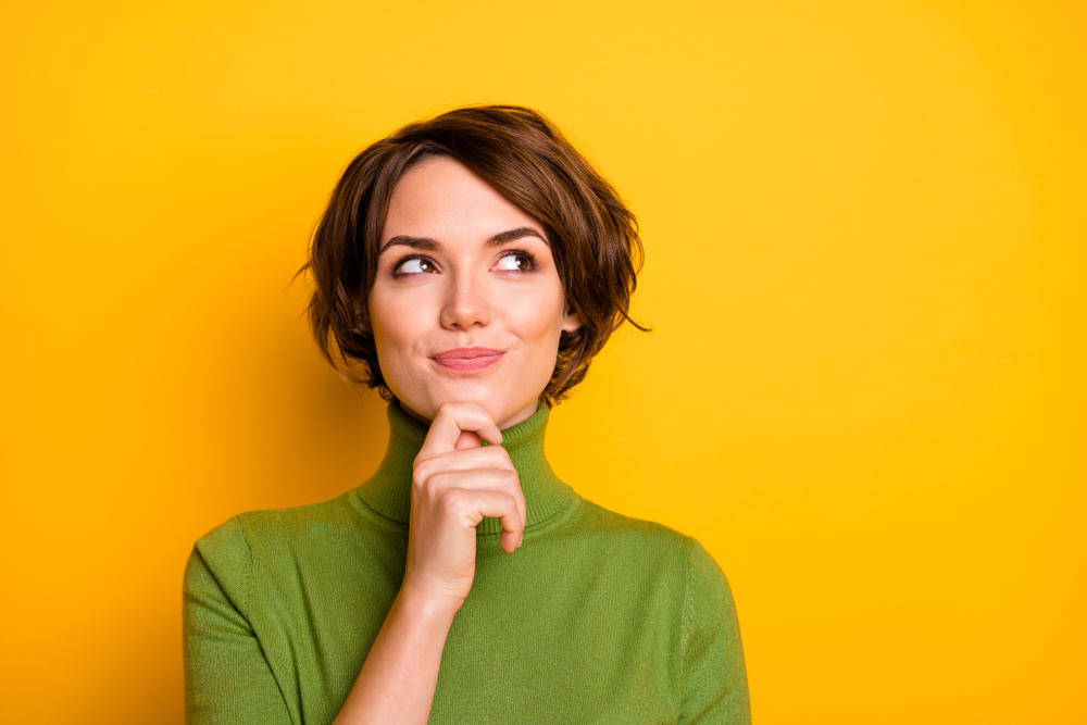 Closeup photo of amazing short hairdo lady looking up empty space deep thinking creative person arm on chin wear casual green turtleneck isolated yellow color background