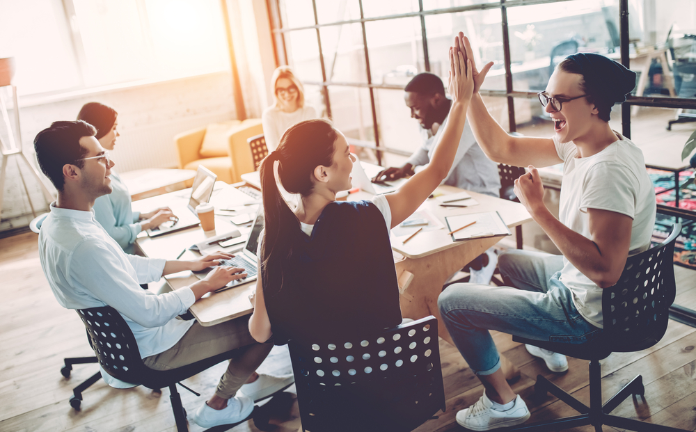 Multiracial young creative people in modern office. Group of young business people are working together with laptop, tablet, smart phone, notebook. Successful hipster team in coworking. Freelancers.