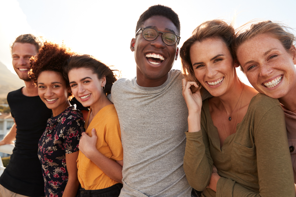 Portrait Of Smiling Young Friends Walking Outdoors Together