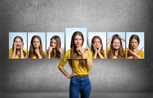 Girl holds and changes her face portraits with different emotions